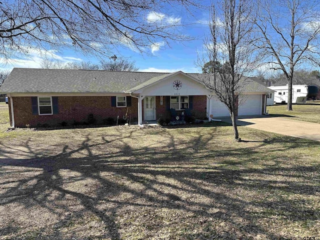 view of front facade with driveway, a front yard, a garage, and brick siding