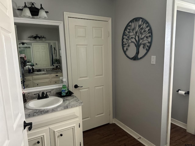 bathroom featuring wood finished floors, vanity, and baseboards