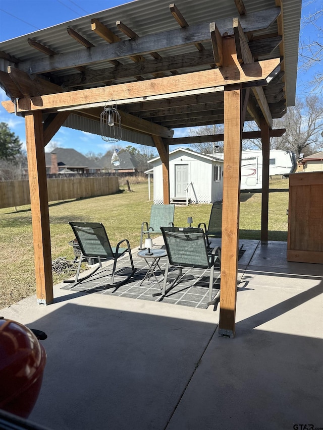 view of patio featuring a storage shed, fence, outdoor dining area, and an outbuilding