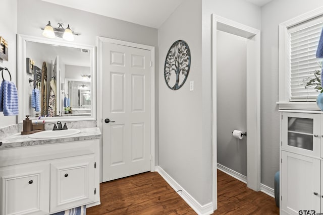 5513 Bostick Dr, Tyler, TX 75707 - bathroom with vanity, wood finished floors, and baseboards