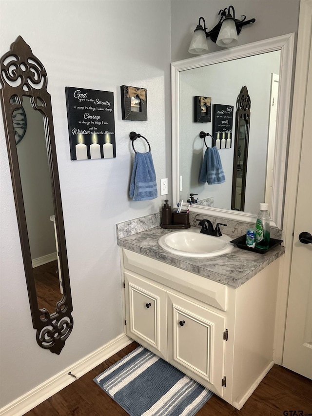 bathroom featuring wood finished floors, vanity, and baseboards