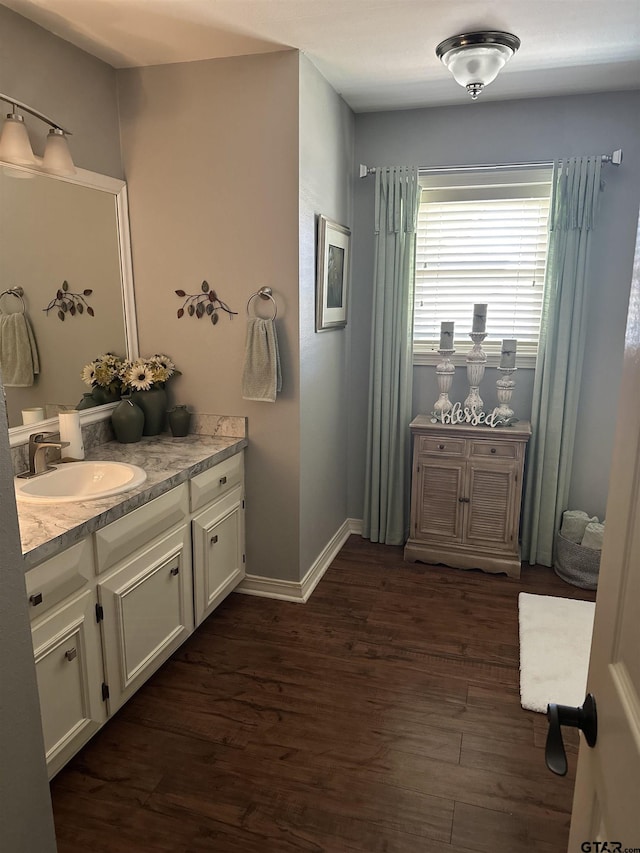 bathroom with vanity, baseboards, and wood finished floors