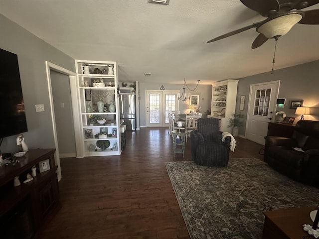 living room featuring dark wood-style floors and ceiling fan with notable chandelier