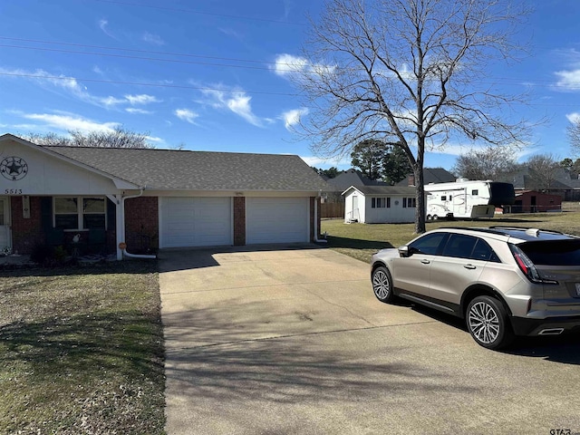 view of front of home with roof with shingles, brick siding, concrete driveway, an attached garage, and a front lawn