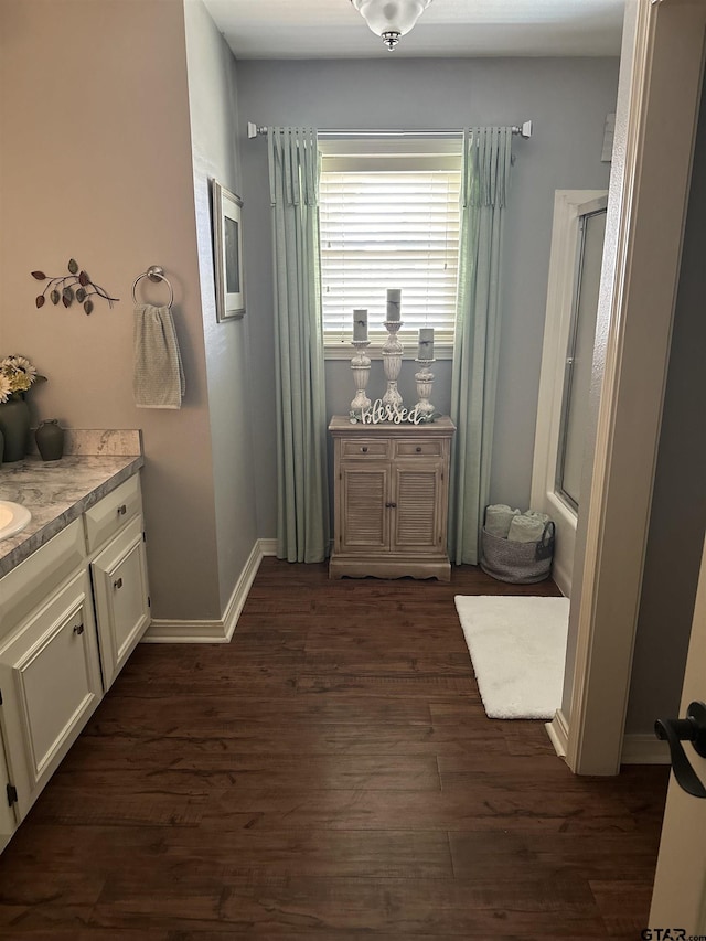 bathroom with vanity, baseboards, and wood finished floors