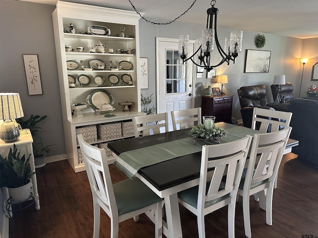 dining space featuring dark wood-style floors, baseboards, and a chandelier