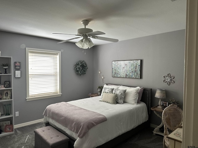 bedroom with baseboards, dark carpet, and ceiling fan