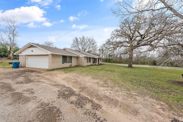 110 N Green St, Hawkins, TX 75765 - view of front of house featuring a front lawn, an attached garage, brick siding, and dirt driveway