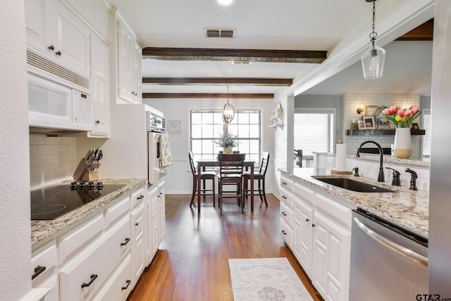 813 W Rieck Rd, Tyler, TX 75703 - kitchen featuring stainless steel appliances, plenty of natural light, tasteful backsplash, white cabinets, and beam ceiling
