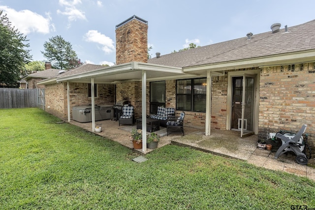 813 W Rieck Rd, Tyler, TX 75703 - rear view of property featuring a hot tub, a patio, a chimney, brick siding, and roof with shingles