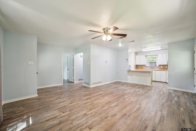 521 Hilltop Dr, Tool, TX 75143 - unfurnished living room featuring ceiling fan, light wood finished floors, and baseboards