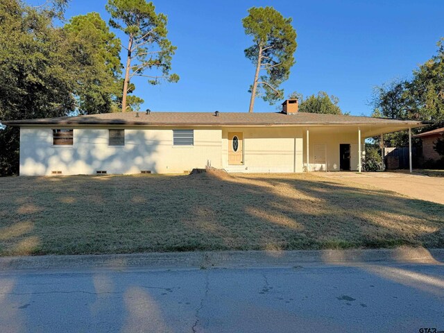 ranch-style house with a front yard and a carport