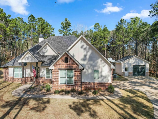 view of front facade featuring a garage, an outdoor structure, and a front yard