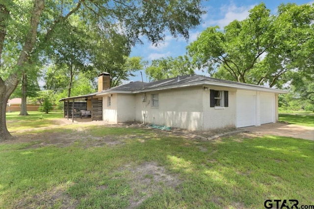150 Gambrell St, Rusk, TX 75785 - view of side of home featuring a chimney, brick siding, a lawn, and a garage