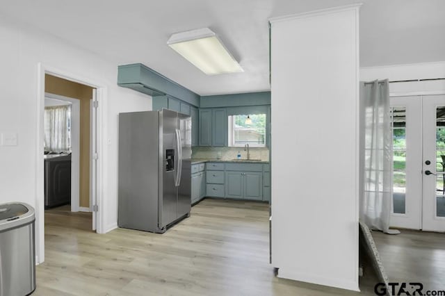 150 Gambrell St, Rusk, TX 75785 - kitchen featuring stainless steel refrigerator with ice dispenser, french doors, washer / dryer, and light wood-type flooring