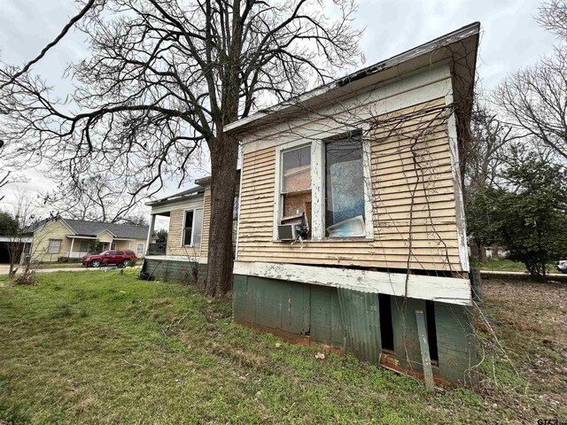 view of property exterior featuring a lawn and cooling unit