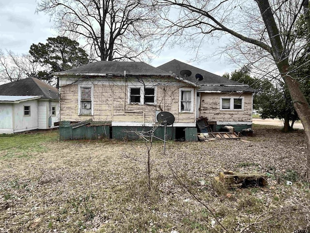 back of property with a shingled roof