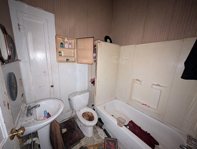 bathroom with toilet and wallpapered walls