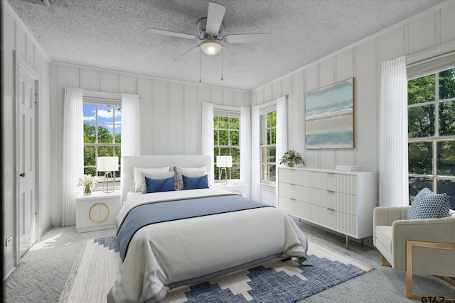 spare room with a decorative wall, a ceiling fan, a textured ceiling, and carpet