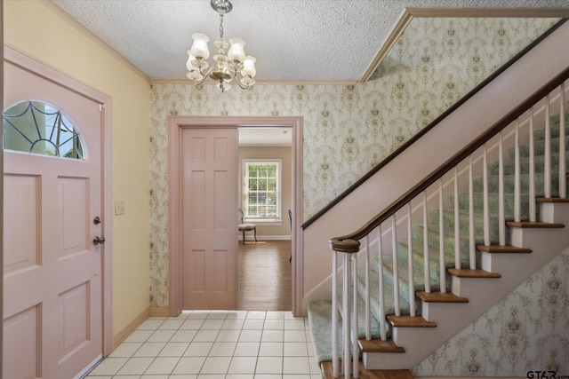 entryway with stairway, a textured ceiling, light tile patterned flooring, baseboards, and a notable chandelier