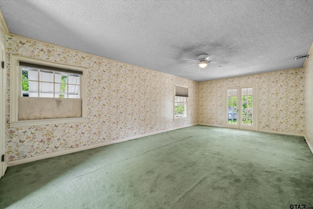spare room featuring wallpapered walls, ceiling fan, baseboards, carpet flooring, and visible vents