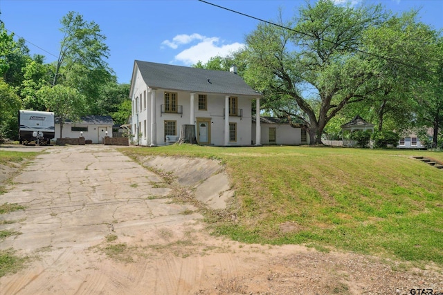 view of front of house featuring stucco siding, driveway, and a front yard