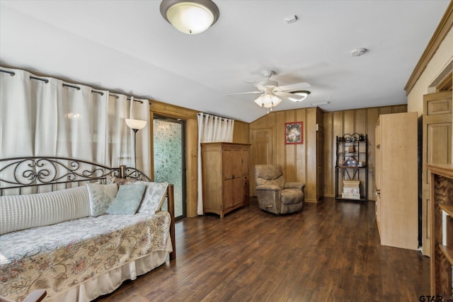 bedroom featuring lofted ceiling, wood finished floors, and wood walls
