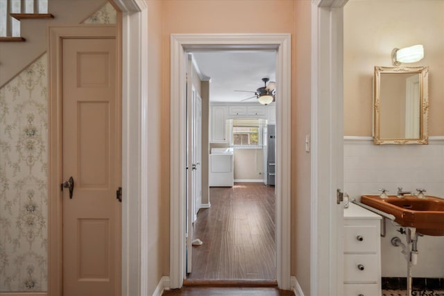 hallway featuring wood finished floors, a sink, and washer / clothes dryer