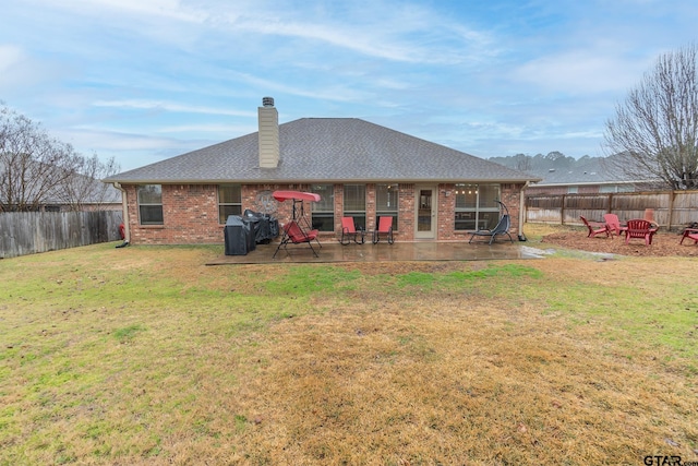 rear view of property featuring a patio and a lawn