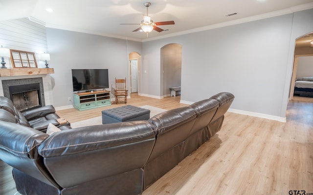 living room with crown molding, ceiling fan, lofted ceiling, and light wood-type flooring