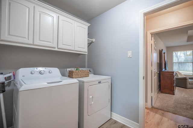 laundry room with cabinets, independent washer and dryer, and light wood-type flooring