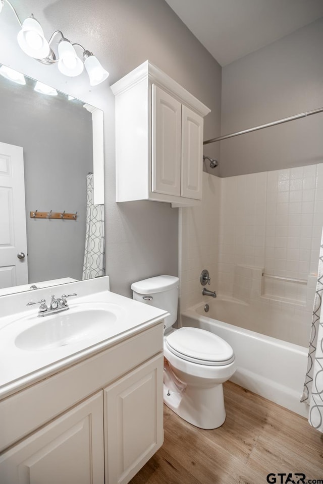 full bathroom featuring wood-type flooring, toilet, shower / bath combination with curtain, and vanity