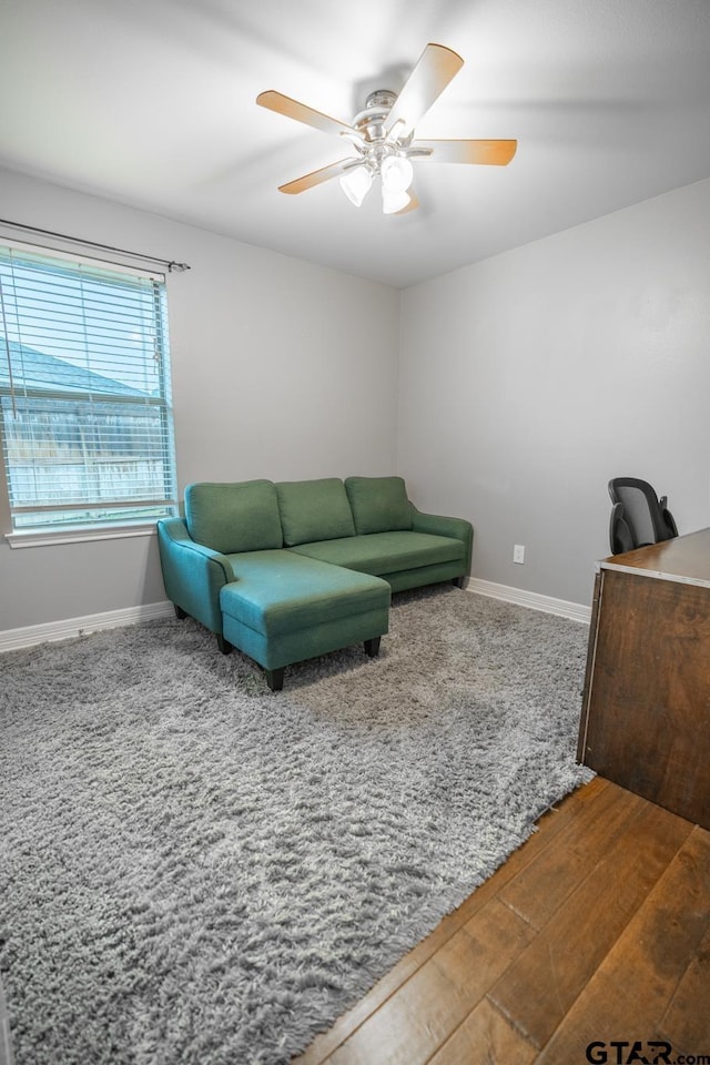 living room with wood-type flooring and ceiling fan