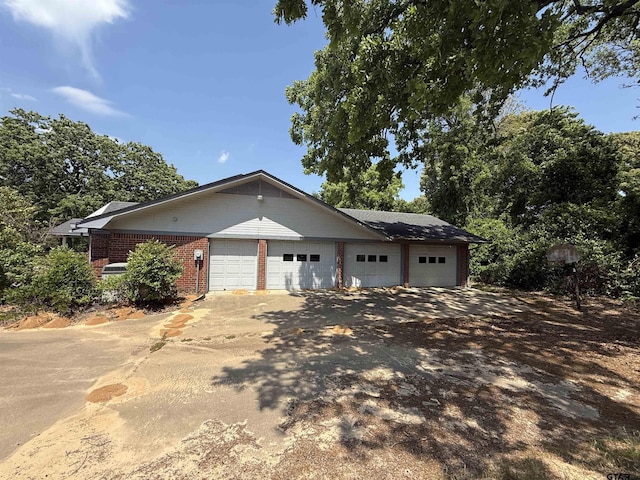 view of property exterior with brick siding and a garage