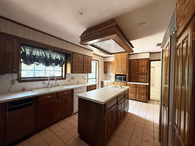 kitchen featuring light countertops, a sink, stainless steel microwave, dishwasher, and light tile patterned floors