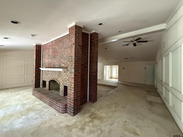 unfurnished living room featuring a fireplace, vaulted ceiling, a decorative wall, and a ceiling fan
