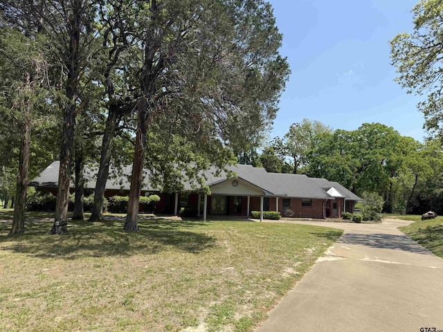 single story home with a front lawn and aphalt driveway