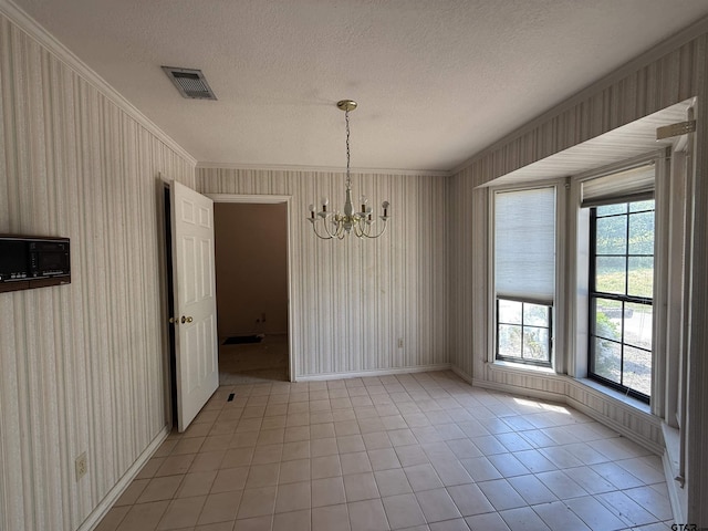 unfurnished dining area featuring an inviting chandelier, crown molding, visible vents, and baseboards