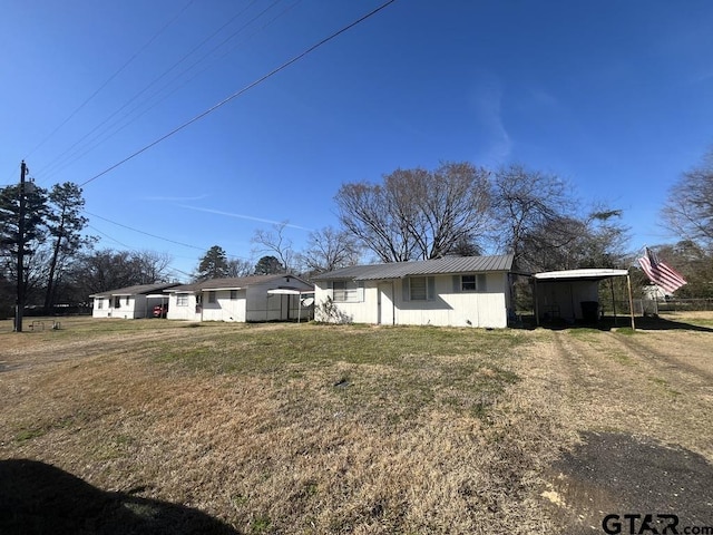 view of front of property with metal roof and a front yard