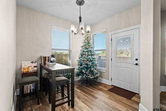 dining area with wood finished floors, baseboards, and a chandelier