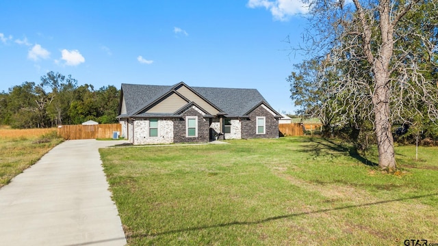 craftsman inspired home with brick siding, concrete driveway, a front yard, and fence