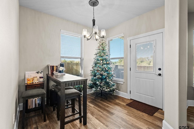 dining room with baseboards, a notable chandelier, and wood finished floors