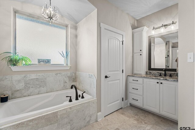 full bathroom featuring a bath, a chandelier, and vanity