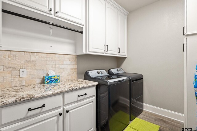 laundry room featuring cabinet space, washing machine and dryer, baseboards, and dark wood-style flooring