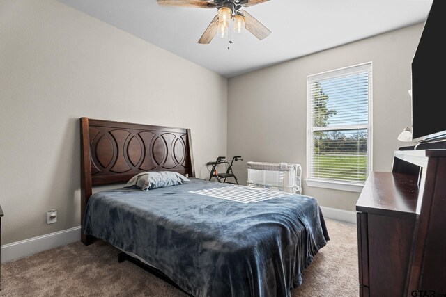 carpeted bedroom with baseboards and a ceiling fan