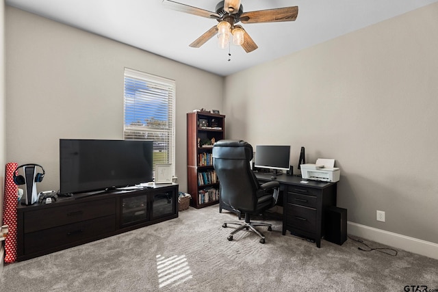 carpeted office featuring baseboards and ceiling fan