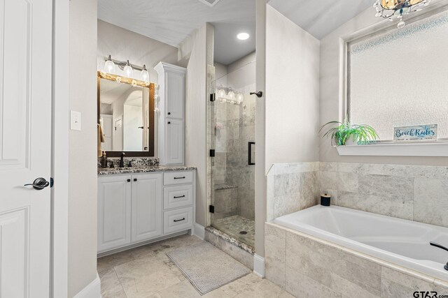 bathroom with vanity, a garden tub, and a shower stall