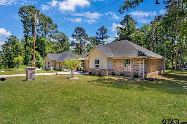 ranch-style house featuring concrete driveway, brick siding, and a front yard