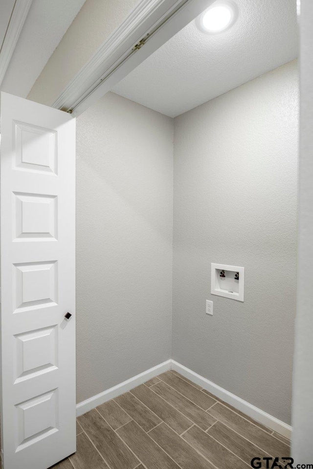 clothes washing area with laundry area, wood finish floors, baseboards, and hookup for a washing machine