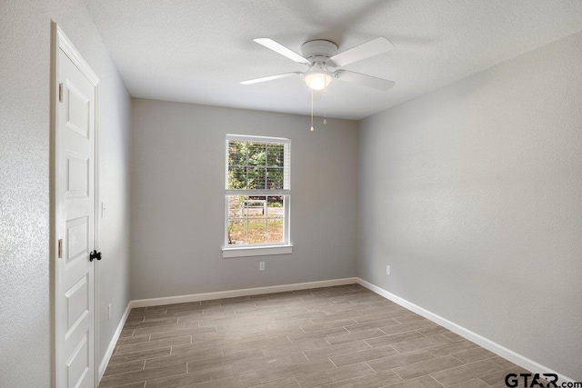 empty room featuring a ceiling fan, baseboards, and wood finished floors
